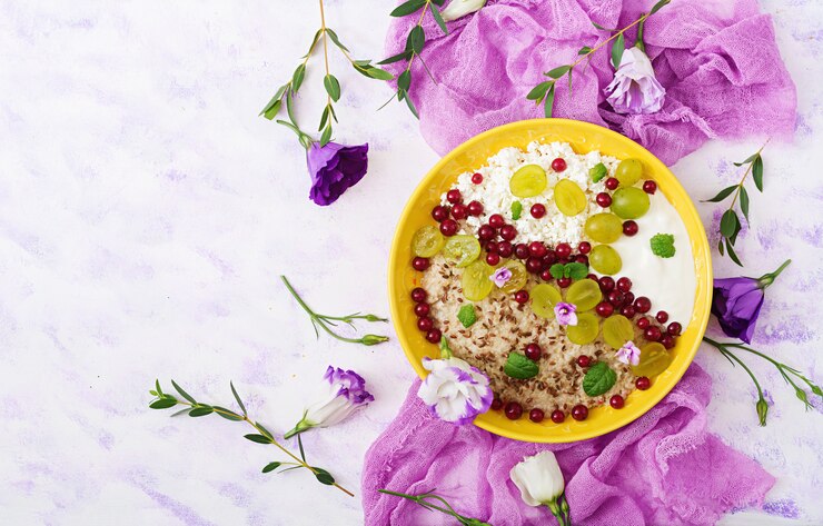 मुफ़्त फोटो delicious and healthy oatmeal with grapes, yogurt and cottage cheese. healthy breakfast. fitness food. proper nutrition. flat lay. top view.