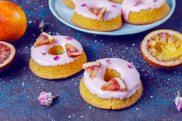 Foto gratuita deliziose ciambelle fatte in casa con glassa di arancia rossa.