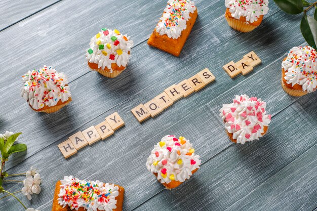 Delicious homemade cupcakes with various sprinkles and Happy Mothers Day words