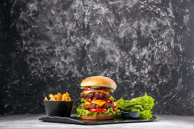 Delicious homemade sandwich and fork ketchup fries green on black tray on gray distressed isolated surface with free space