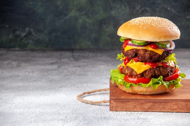 Free photo delicious homemade sandwich on wooden board tied up with rope on the left side on blurred surface with free space