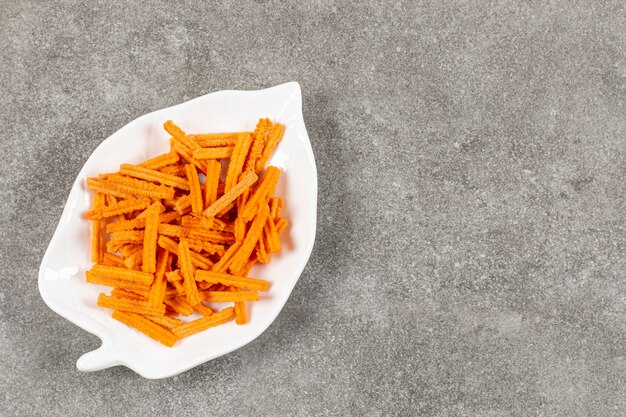 Delicious hot chips on white plate .