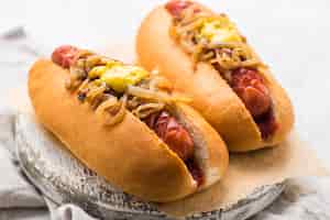Foto gratuita deliziosi hot dog con senape e cipolla
