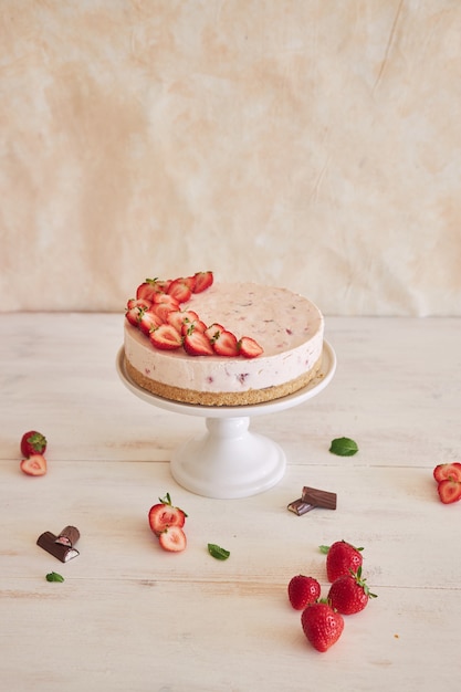 Foto gratuita deliziosa torta gelato allo yogurt con fondo di biscotto e fragole