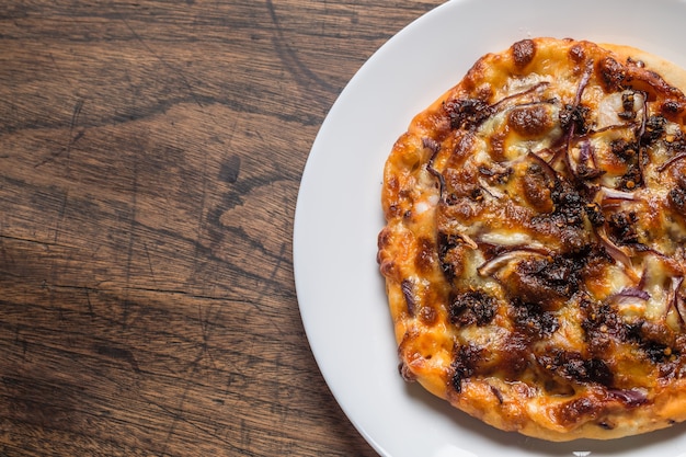 木製​の​テーブル​で​おいしい​イタリアン​ピザ​提供