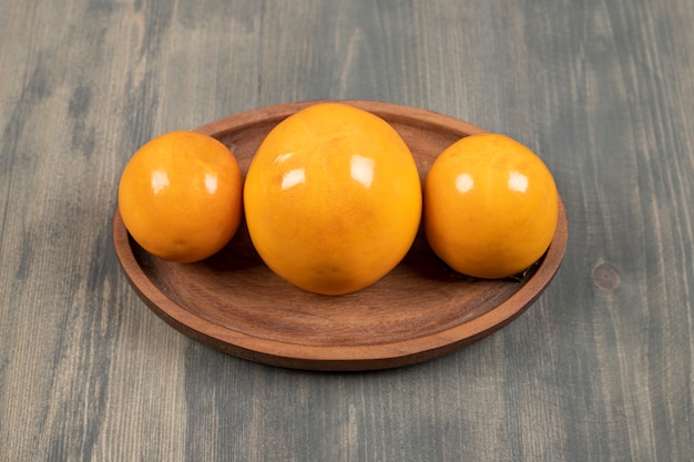 Delicious juicy persimmons on a wooden board. High quality photo