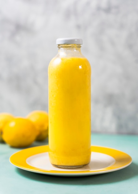 Delicious lemon juice bottle on plate