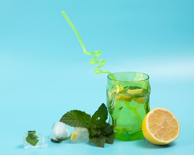 Delicious lemonade with mint leaves on blue background