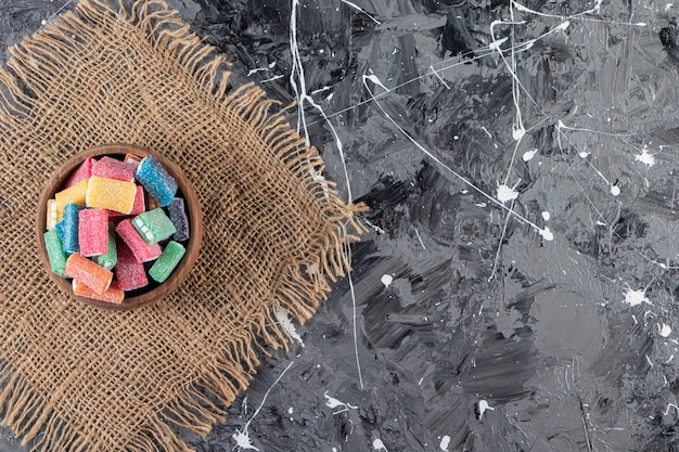 Delicious licorice in wooden bowl placed on marble table.