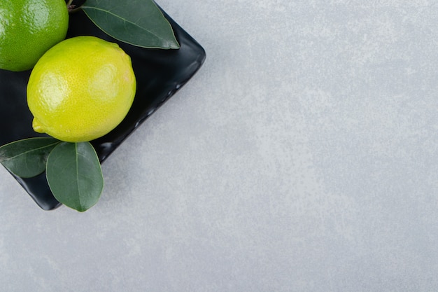 Free photo delicious lime fruits on black plate