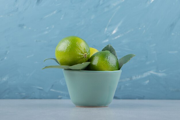 Delicious lime fruits in blue bowl. 