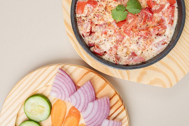 Delicious meal with sliced vegetables on wooden board.