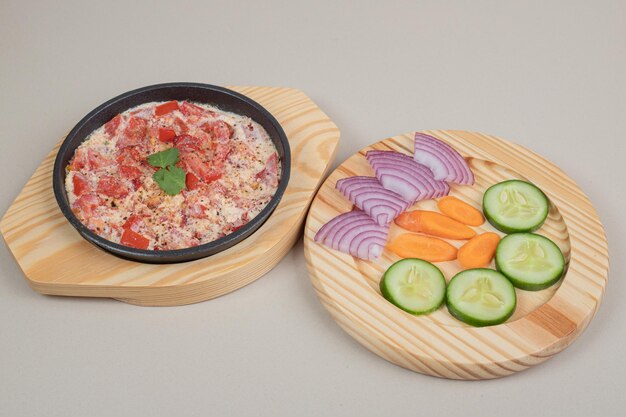 Delicious meal with sliced vegetables on wooden board.