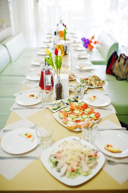 Delicious meals such as salad and canapes laying on the laid table