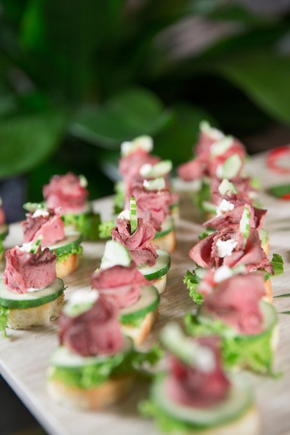 Free photo delicious mini canapes with meat on buffet table