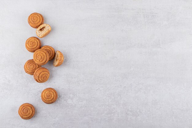 Delicious mini cinnamon cakes placed on stone table.