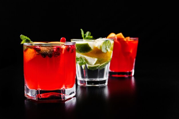 Delicious mojito, rum and cola, blood orange and vodka cocktails served with fruit