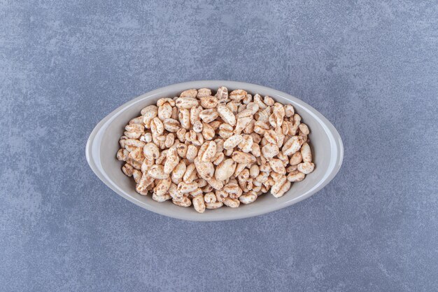 Delicious muesli in a bowl, on the blue table.