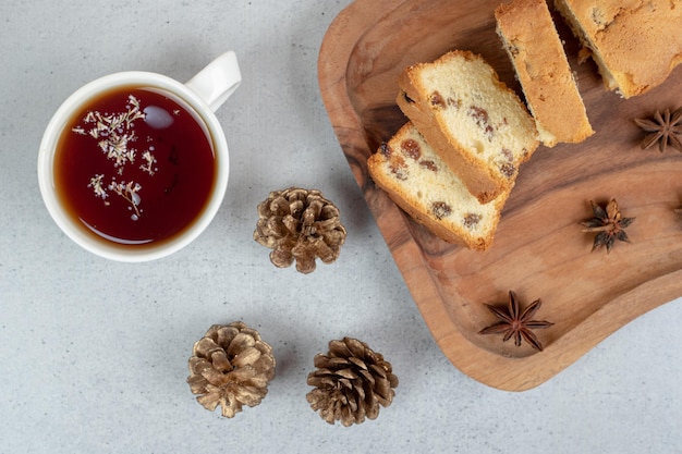 Delizioso muffin con uvetta e tazza di tè sulla tavola di legno.