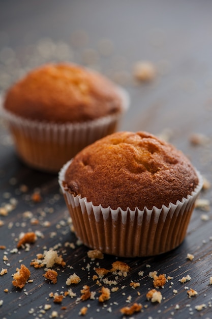 delicious muffins with the crumbs on the wooden surface