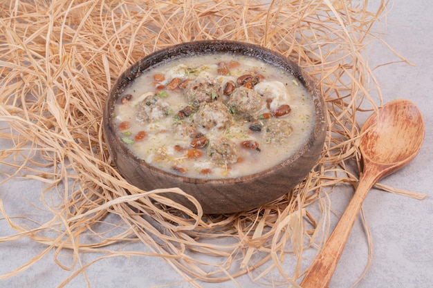 Deliziosa zuppa di funghi in ciotola di legno con cucchiaio.