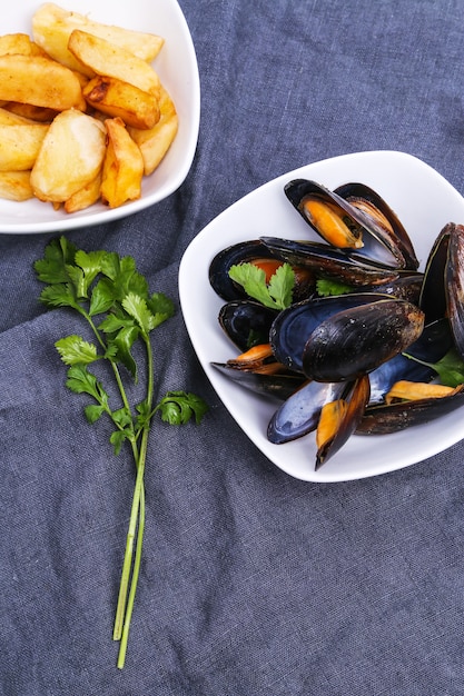 Delicious mussels on blue tablecloth