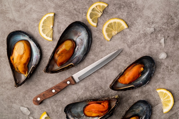 Deliziose cozze e coltello distesi piatti