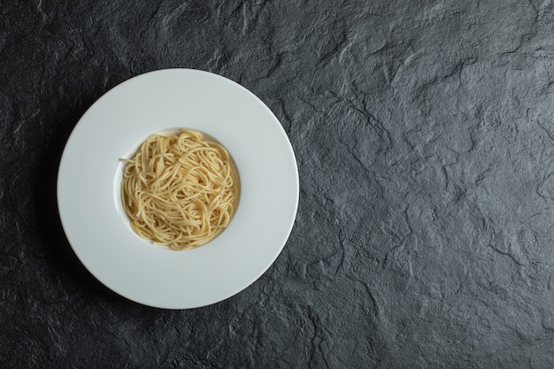 Бесплатное фото Вкусная лапша в белой тарелке на черном.