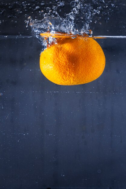 Delicious orange falling in water