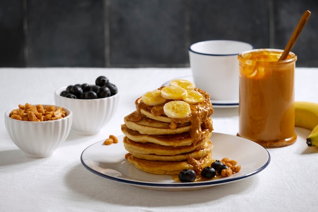 Free photo delicious pancakes with peanut butter arrangement