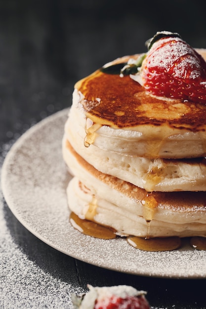 Delicious pancakes with strawberries and honey