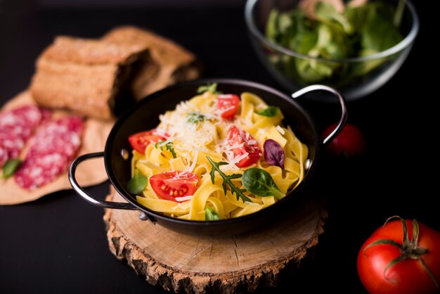 Delicious pasta for breakfast in container over wooden coaster