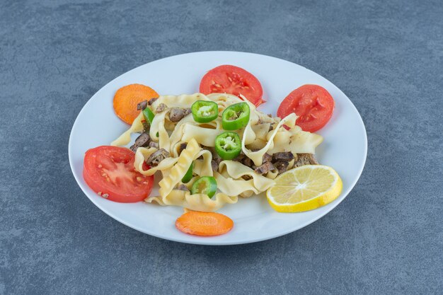 Delicious pasta with vegetables on white plate. 