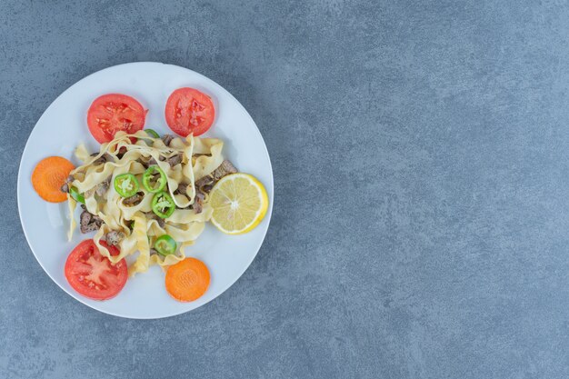 Delicious pasta with vegetables on white plate. 