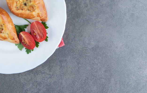 Delicious pastries with cherry tomatoes in a white plate