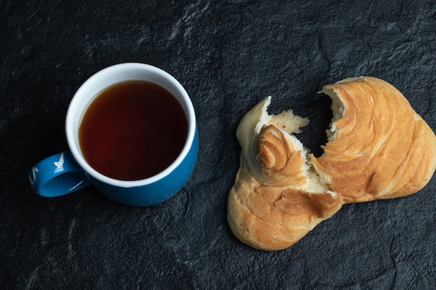 Deliziosa pasticceria con una tazza di tè sul nero.