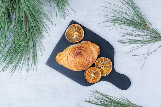 Delicious pastry with dried orange slices on black board. High quality photo