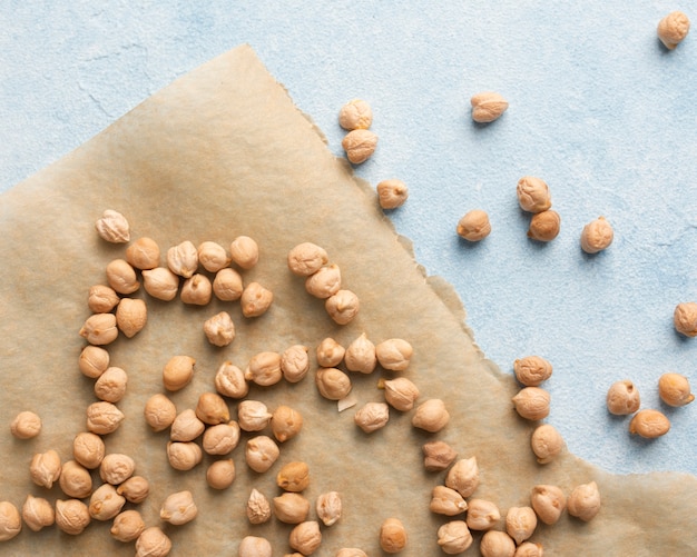Delicious peanuts spread on paper and blue table