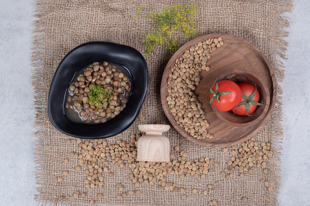 Delicious peas with tomatoes on wooden plate. High quality photo