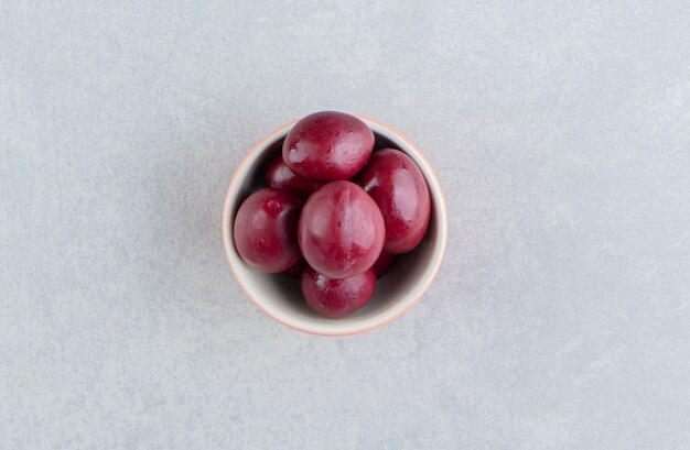 Delicious pickled plum in a bowl on the marble surface