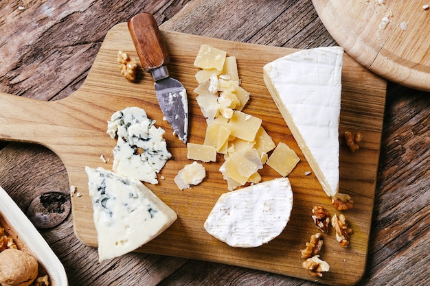 Delicious pieces of cheese wooden board