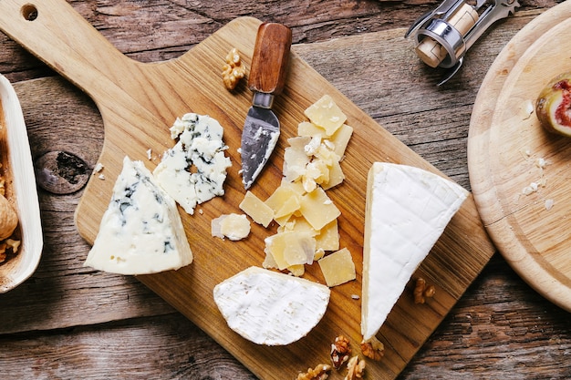 Free photo delicious pieces of cheese wooden board