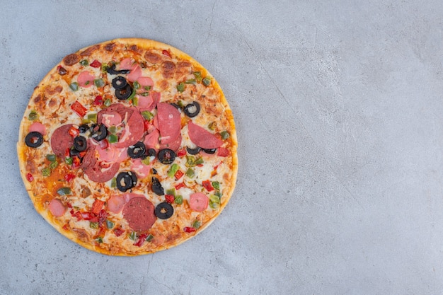 Delicious pizza displayed on marble background.