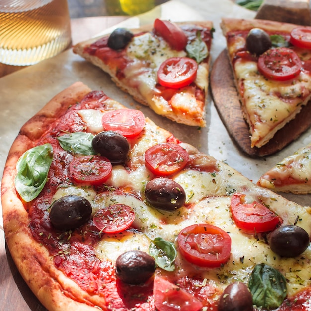 Delicious pizza with cheese and cherry tomato slices on wooden table