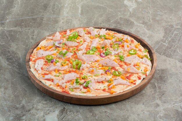 Delicious pizza with chicken meat on wooden board. High quality photo