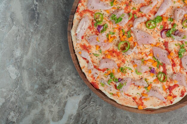 Delicious pizza with chicken meat on wooden board. High quality photo