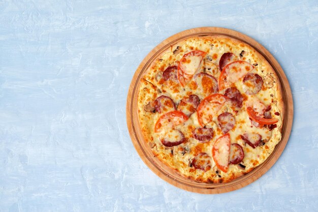 Вкусная пицца с сосисками на сером фоне