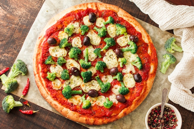 Delicious pizza on wooden table with ingredients