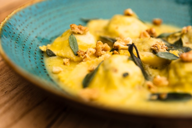 Foto gratuita piatto delizioso della pasta cucinata dei ravioli sulla tavola di legno