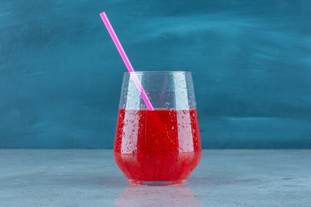 Delicious pomegranate juice with seeds and straw . 